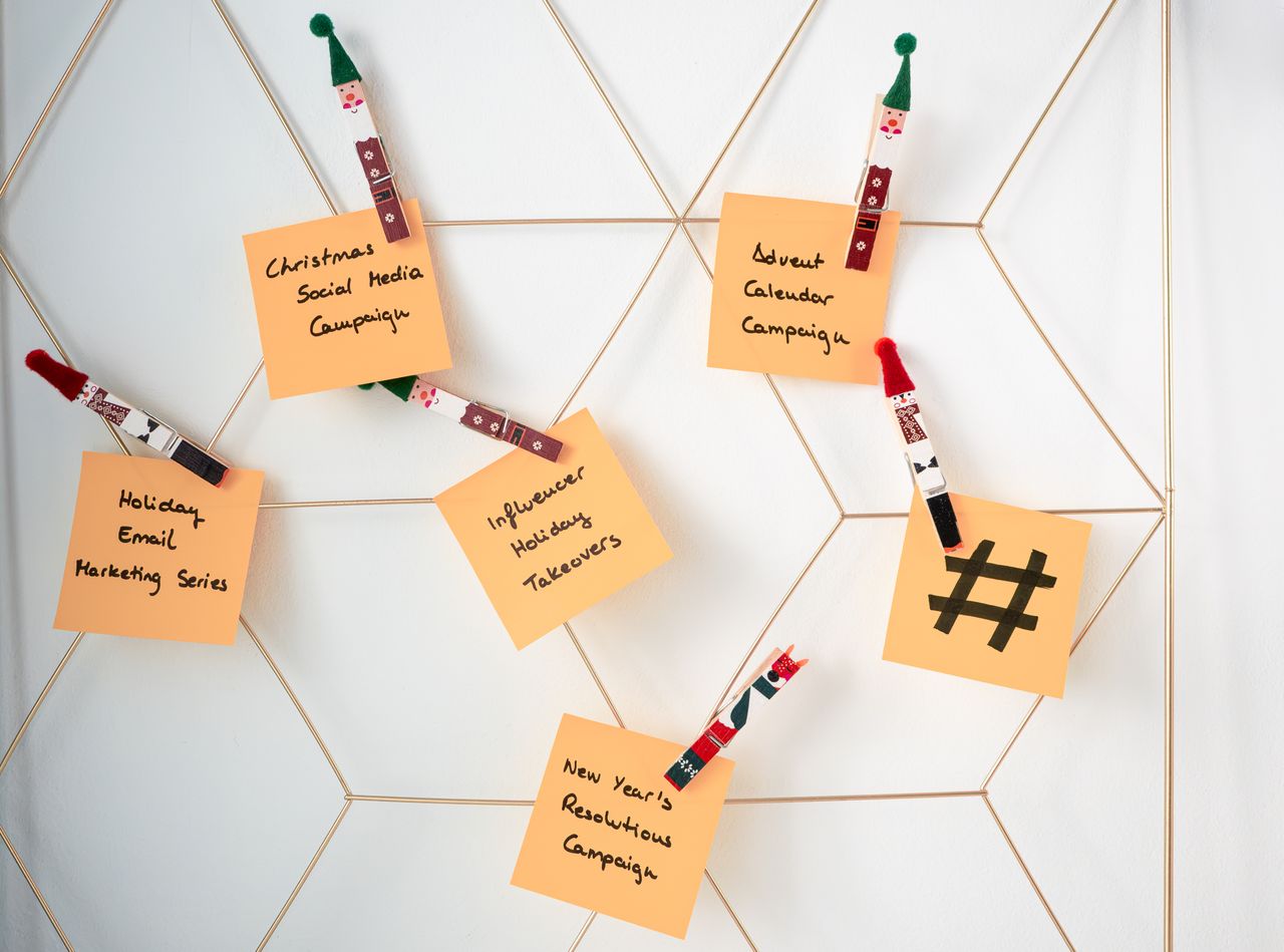 Post-it con idee di marketing per le festività fissati a una griglia a parete.