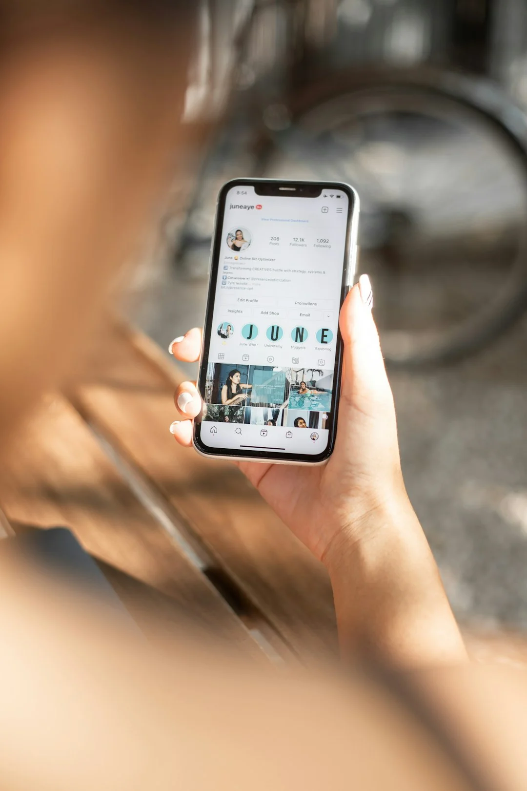 Una vista ravvicinata di uno schermo di smartphone che mostra la posta in arrivo, tenuto nella mano di un adulto.